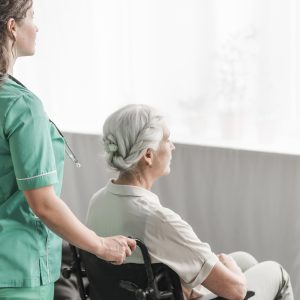 side-view-nurse-pushing-disabled-patient-wheel-chair