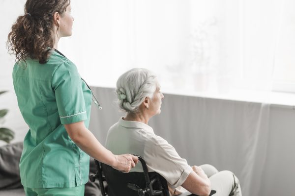 side-view-nurse-pushing-disabled-patient-wheel-chair